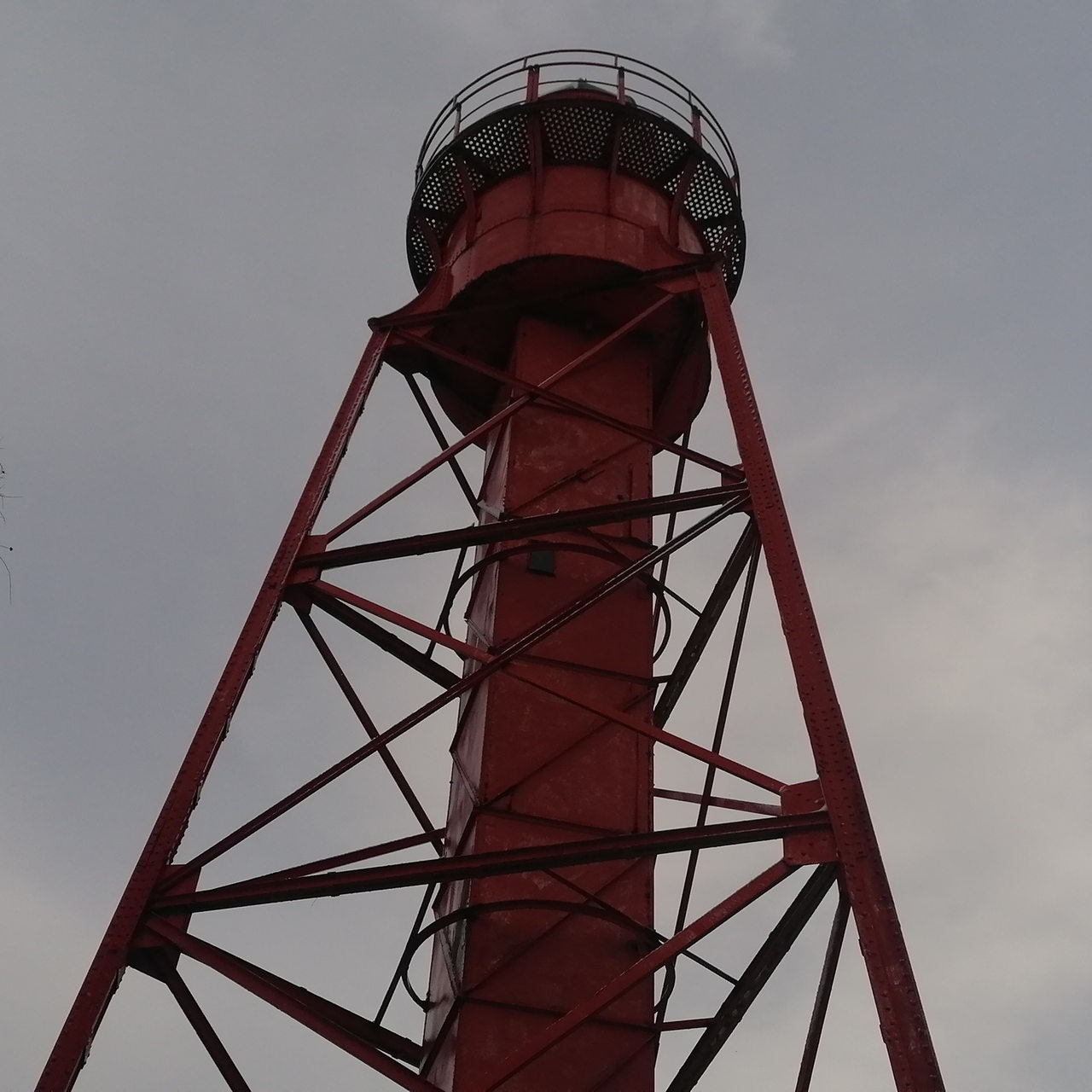 Ein alter roter Leuchturm steht in einer verschneiten Landschaft