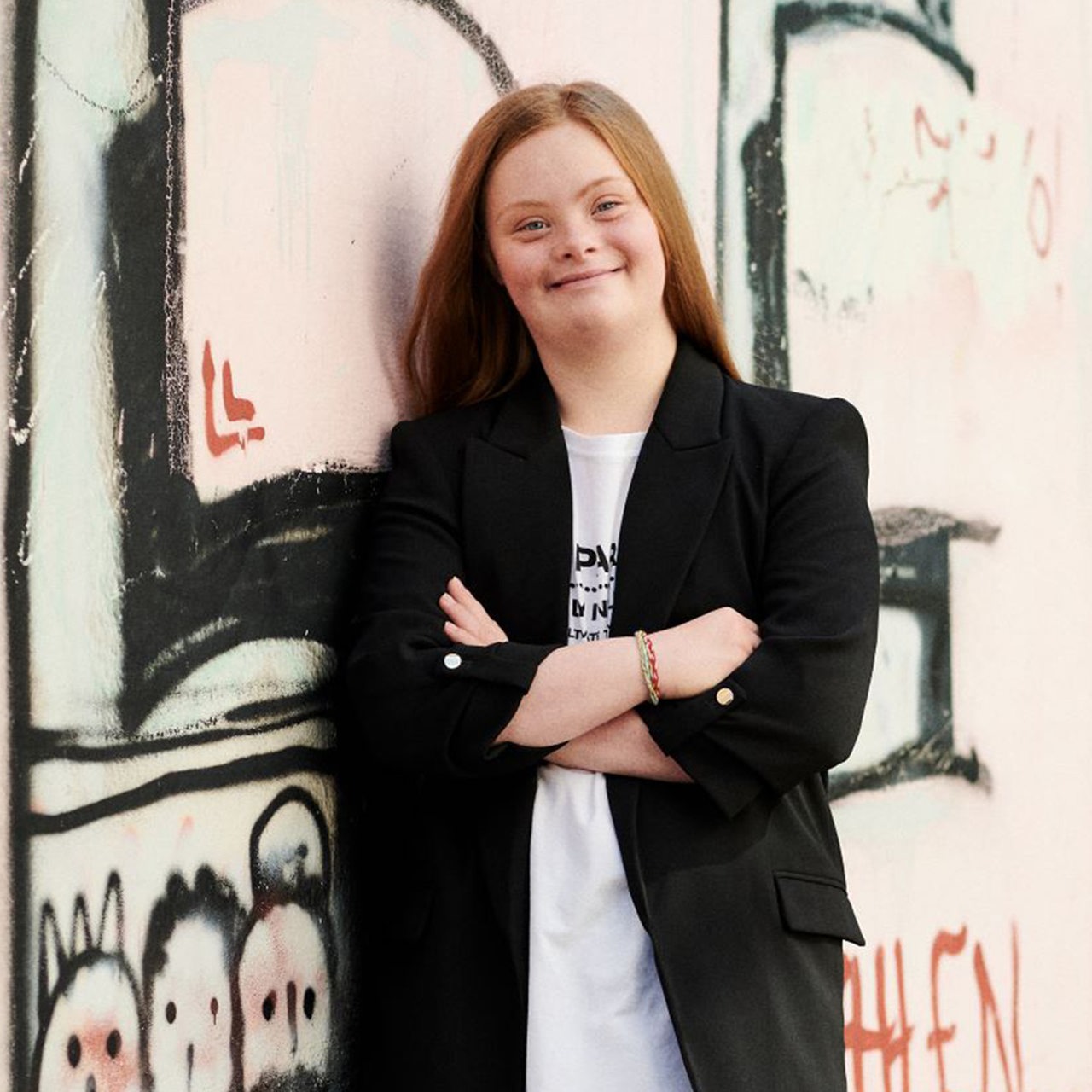 Amelie Gerdes steht vor einer mit Graffity bemalten Wand