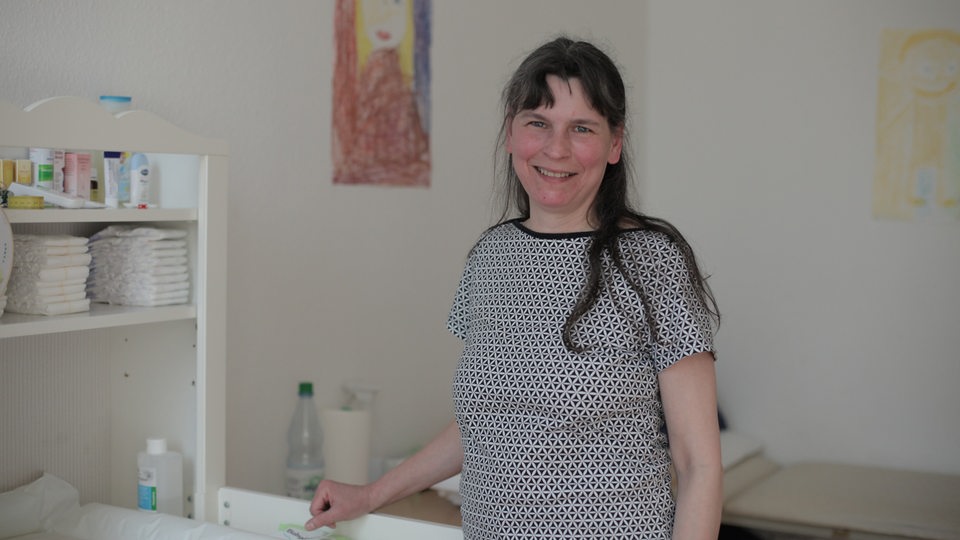 Andrea Lehmann steht vor einem Babybett