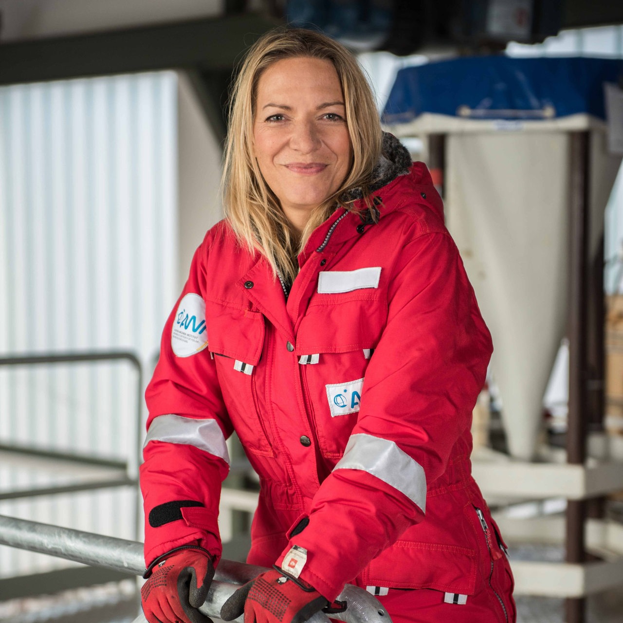 Antje Boetius sitzt in Arbeitskleidung auf einer Treppe an Bord der Polarstern