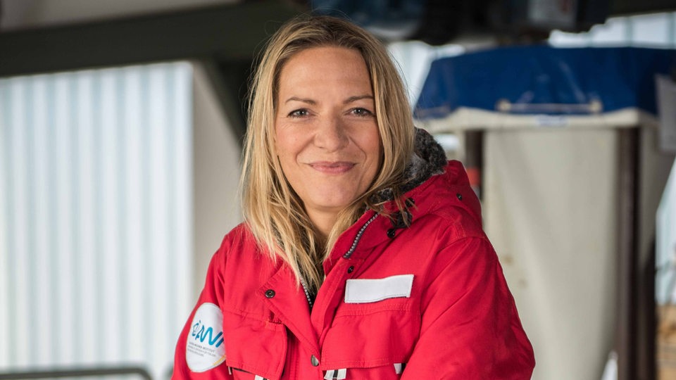 Antje Boetius sitzt in Arbeitskleidung auf einer Treppe an Bord der Polarstern