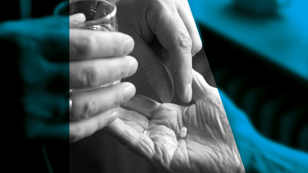 Grafik zeigt die Hand einer alten Person, in die von einer anderen Person eine Tablette gelegt wird