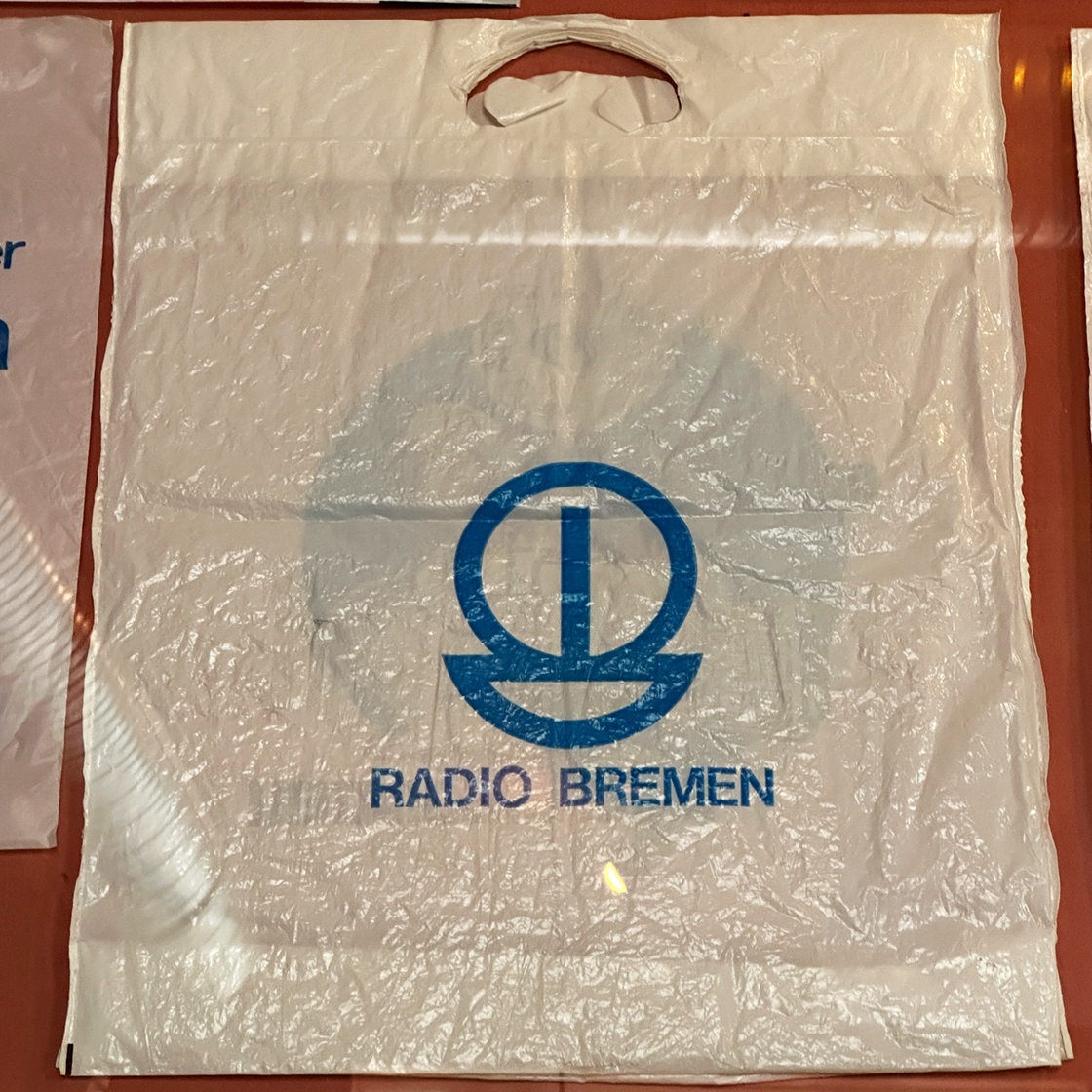 Eine weiße Plastiktüte mit dem alten Zeichen von Radio Bremen in blau drauf