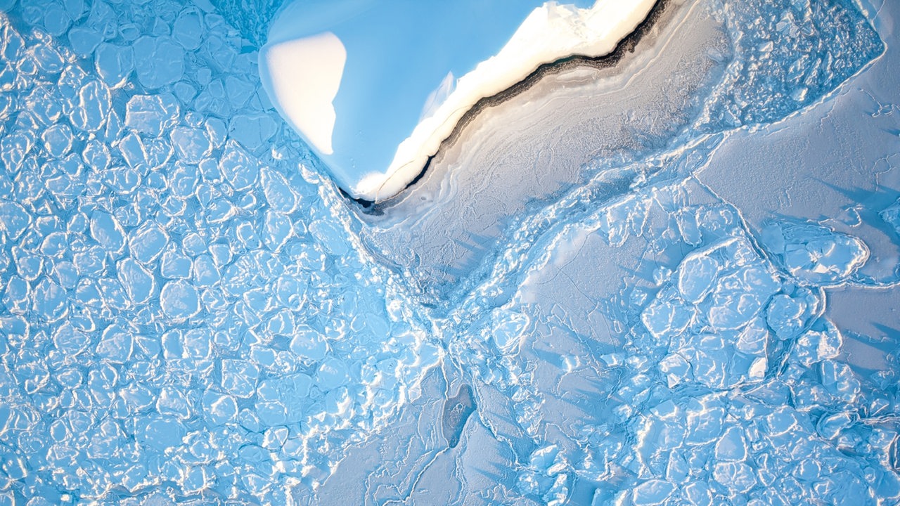 Ein Eisberg treibt im Wedellmeer durch Pfannkucheneis.