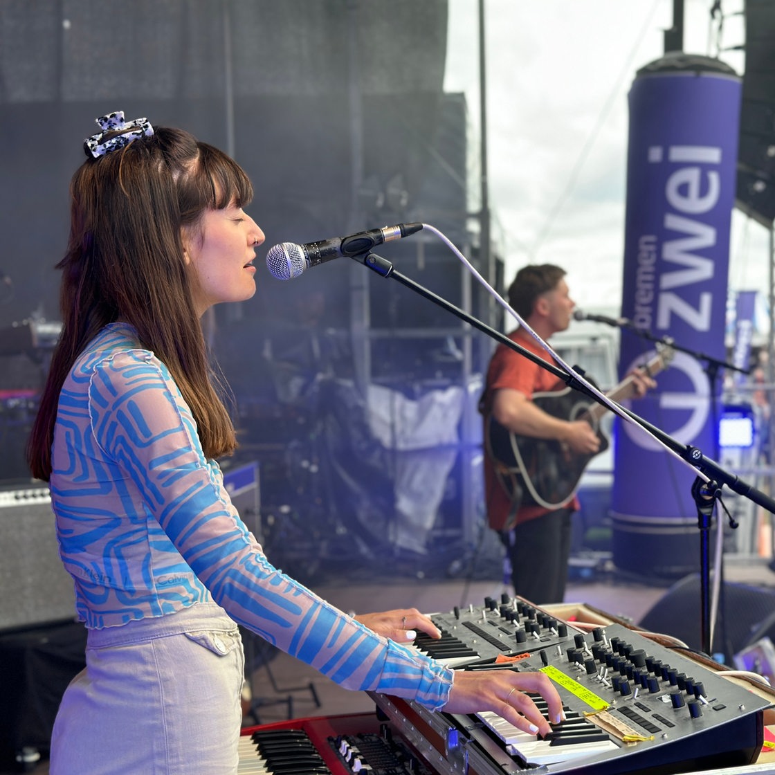 Die Band Havington spielt auf der Bremen-Zwei-Bühne im Rahmen der Breminale 2023, die Sängerin steht am Keyboard und singt