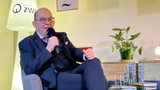 Denis Scheck sitzt auf einem Sessel auf der Bremen Zwei Bühne