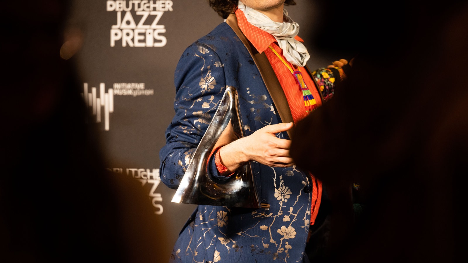 Ein Mann hält die Trophäe des Deutschen Jazzpreises