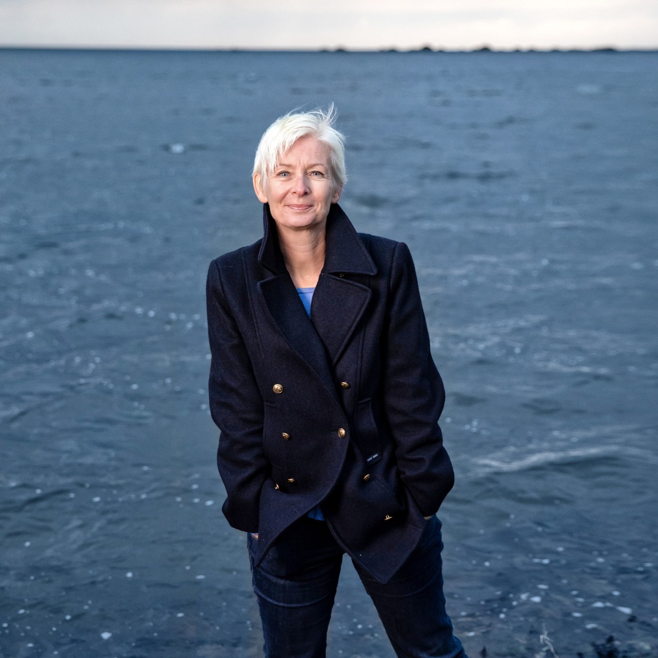 Schriftstellerin Dörte Hansen steht an einem Strand