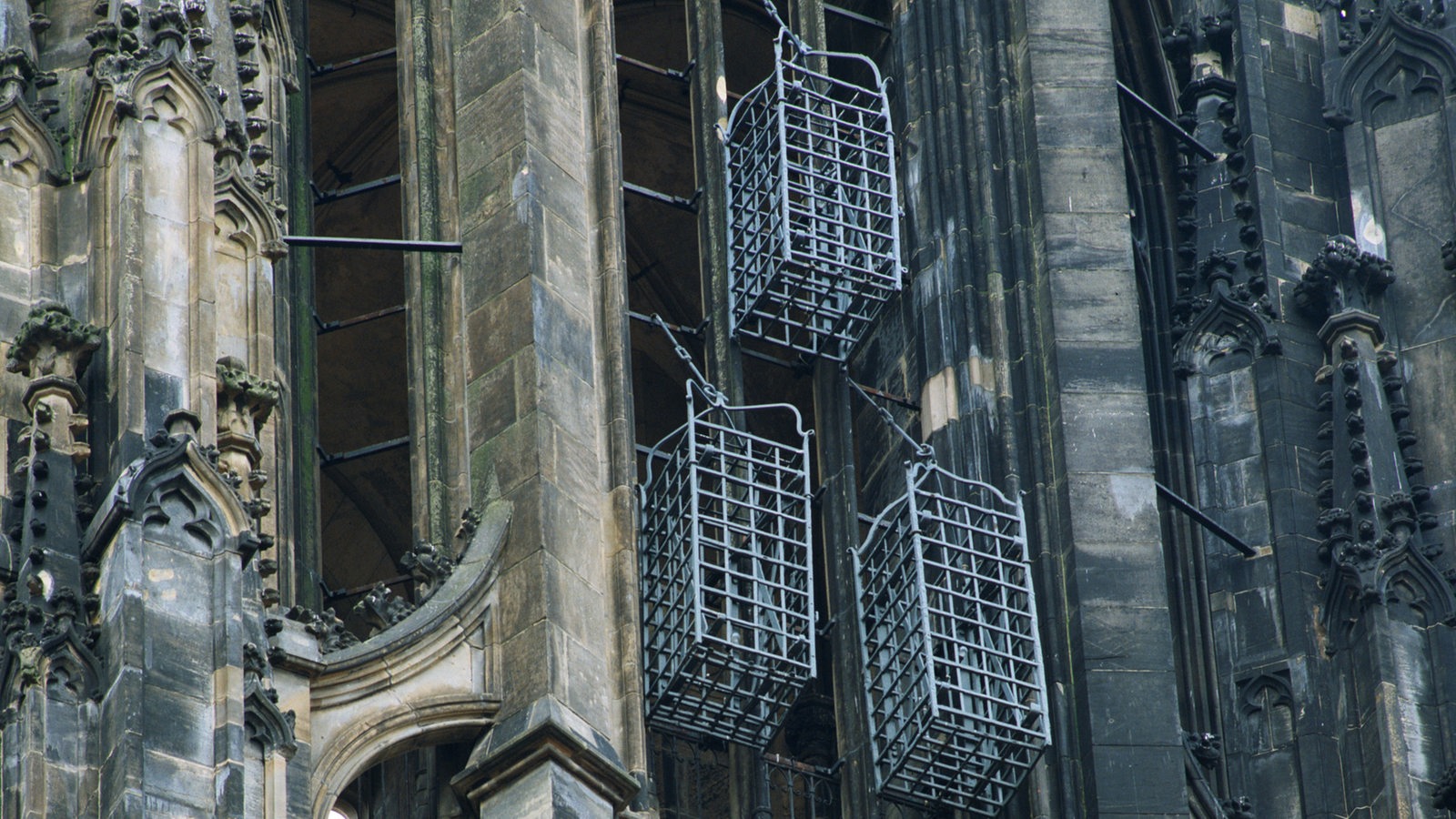 Käfige hängen an einem Turm der Lambertikirche Münster.
