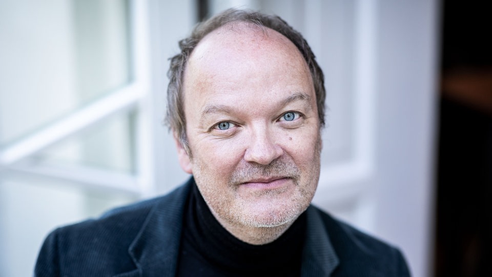 Jens Wawrczeck, Schauspieler und Sprecher, schaut in die Kamera 