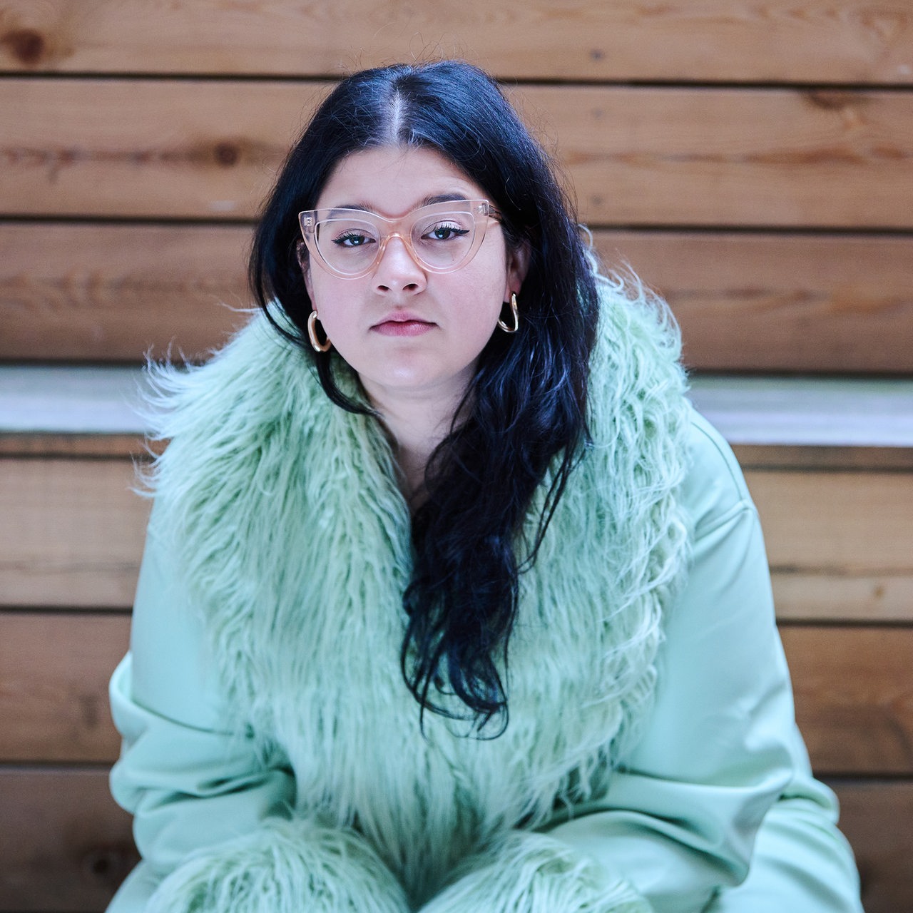Yasmine M'Barek, Journalistin und Autorin, sitzt auf Stufen in Berlin