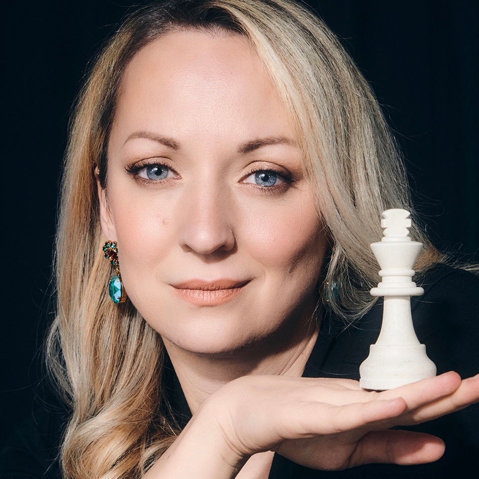 Ein Porträt von Elisabeth Pähtz mit einer Schach-Figur in der Hand.