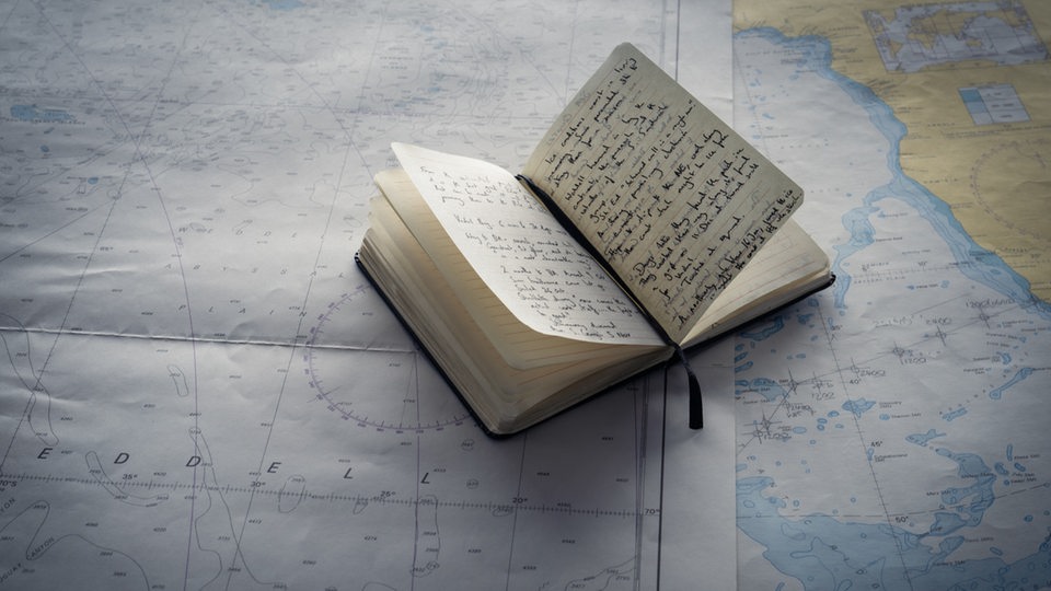 Logbuch mit Notizen auf einer Seekarte