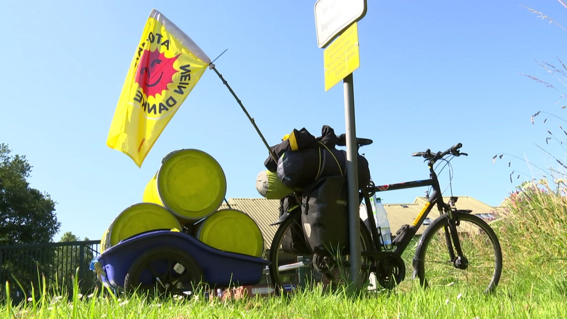 Das Rad eines Anti-Atomkraft Fahrradkorsos lehnt mit einer wehenden Flagge an einem Masten.