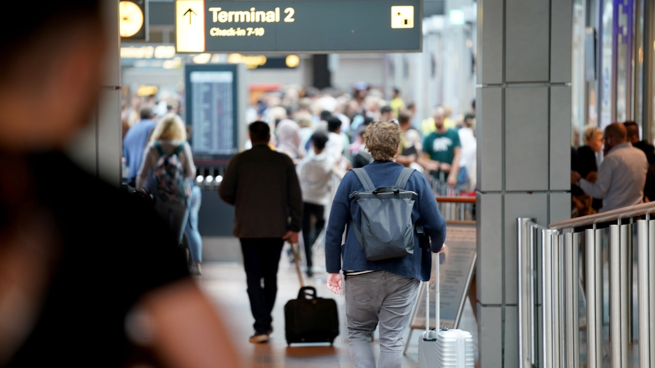 Flugreisende gehen zur Sicherheitskontrolle am Airport Hamburg.