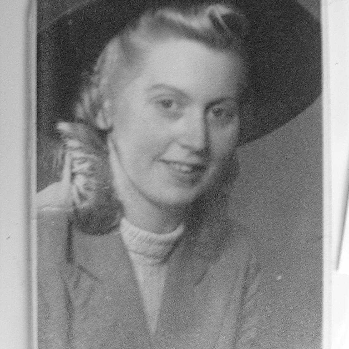 Ingeborg Ahner Siesen portraitiert in den 1940er Jahren im hellen Kostüm mit offenem Haar und dunklem Hut