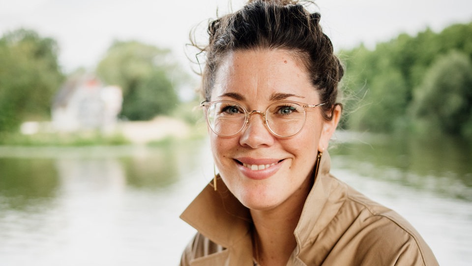 Meeresbiologin Frauke Bagusche steht auf einer Brücke und lächelt in die Kamera