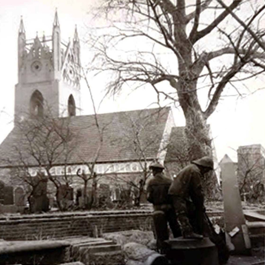 historische Aufnahme des Fürbringer Brunnens in Emden, zerlegt in Einzellteile,im Hintergrund eine Kirche