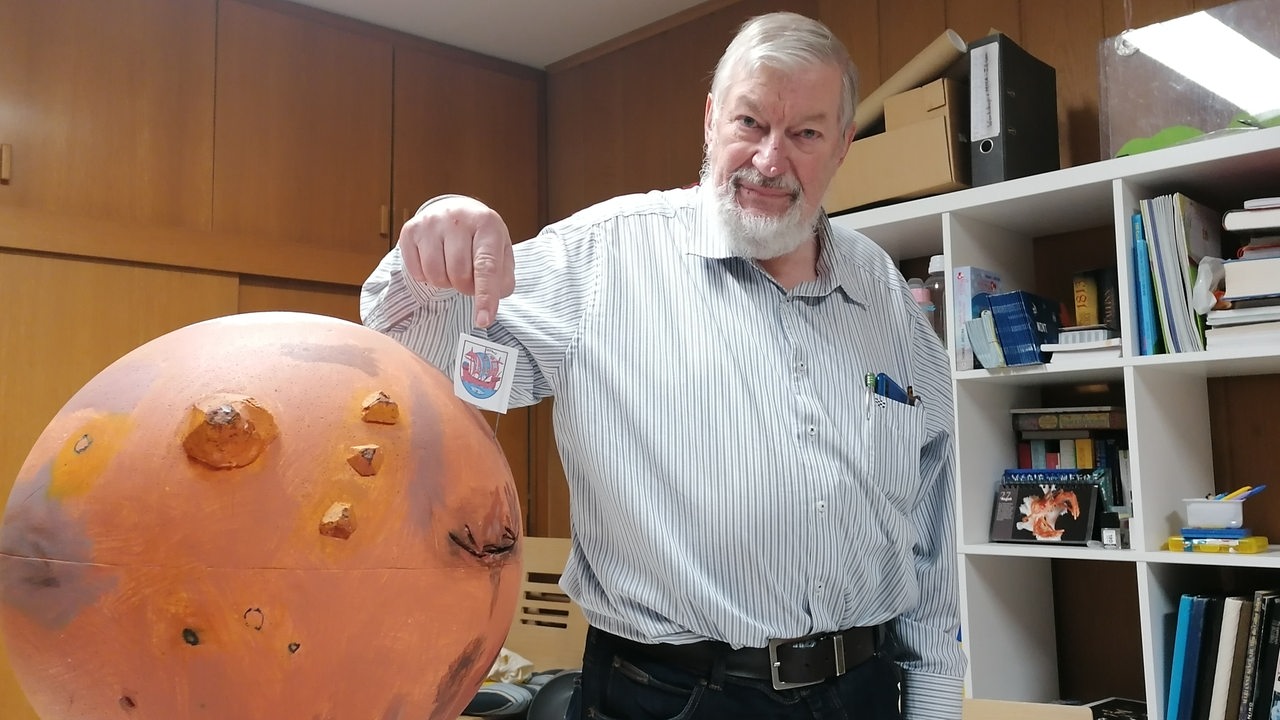 Günter Neumann mit Mars-Modell, auf dem das Bremerhavener Wappen gesteckt ist.