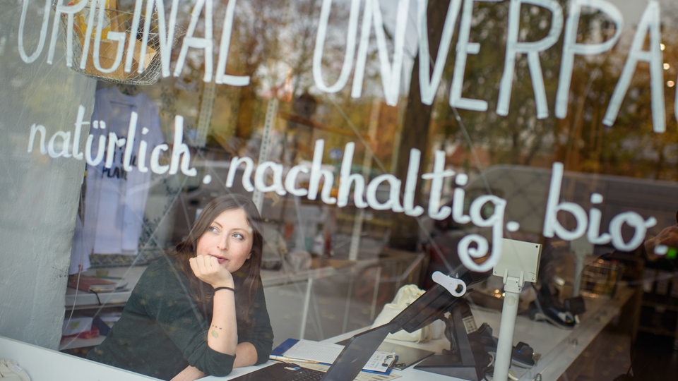 02.11.2018, Berlin: Milena Glimbovski, Gründerin und Geschäftsführerin des Ladens "Original Unverpackt", schaut kurz nach Ladenöffnung aus dem Schaufenster auf die Straße.