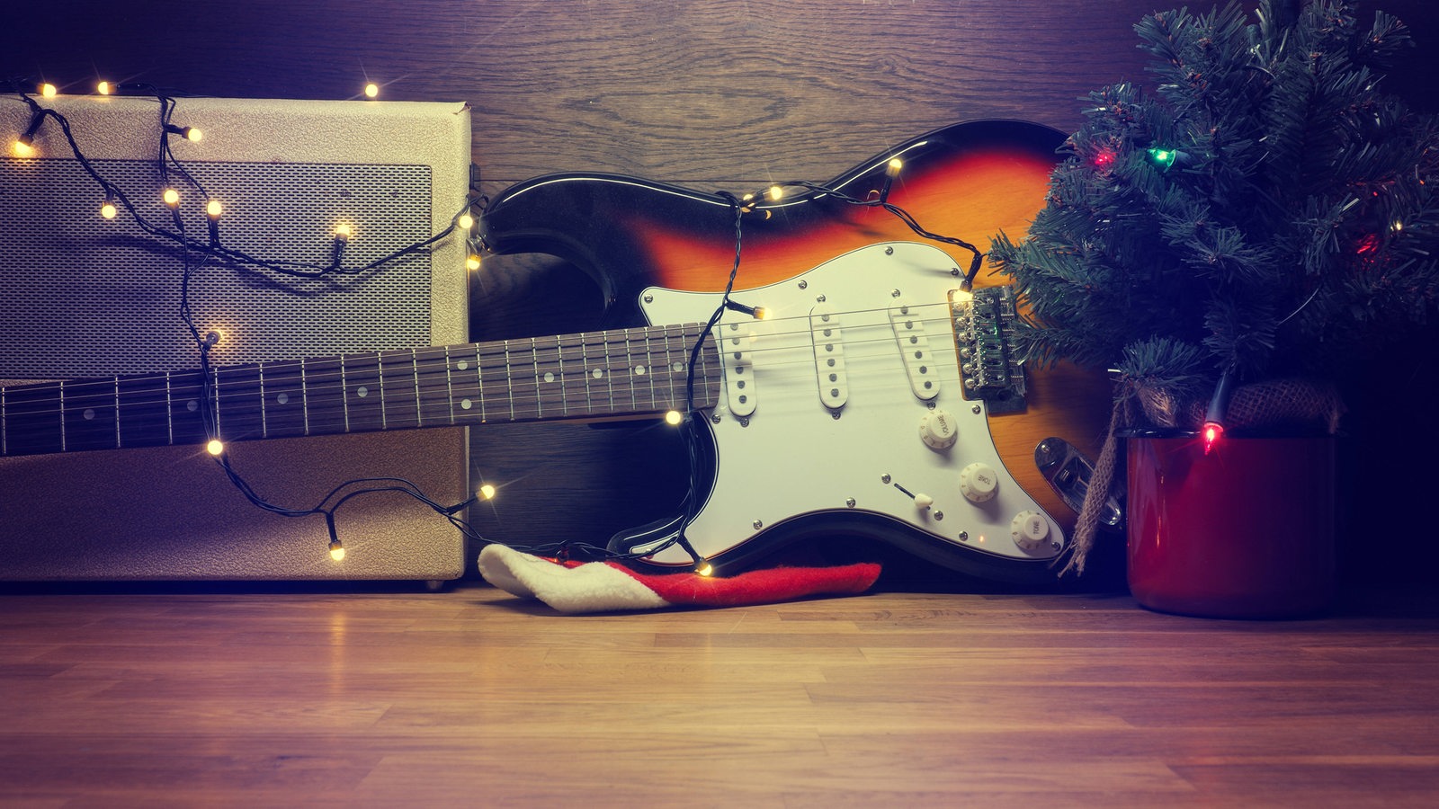 Eine E-Gitarre neben einem kleinen Weihnachtsbaum und einem Verstärker
