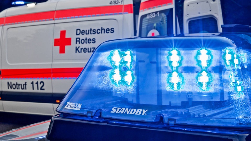 Blaulicht eines Polizeifahrzeugs im Vordergrund, im Hintergrund ein Krankenwagen