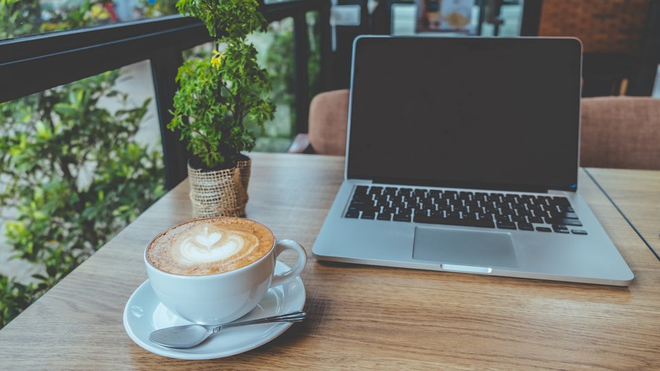 Ein Laptop auf einem Tisch mit einem Café