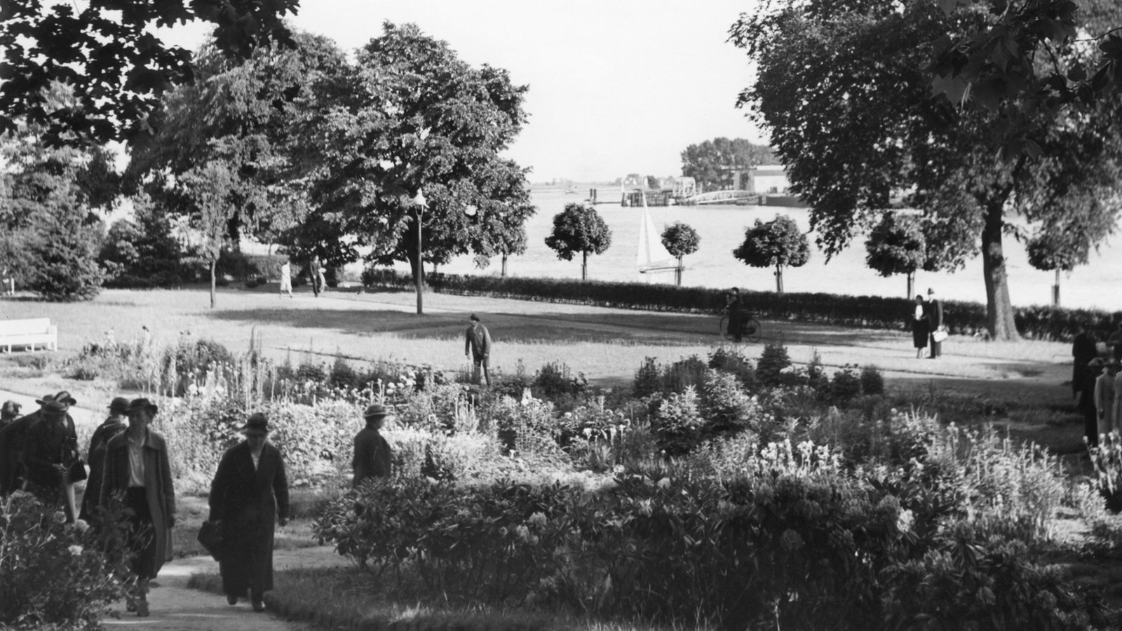 Spaziergänger in einem PArk am Fluss (historische Aufnahme 1938)