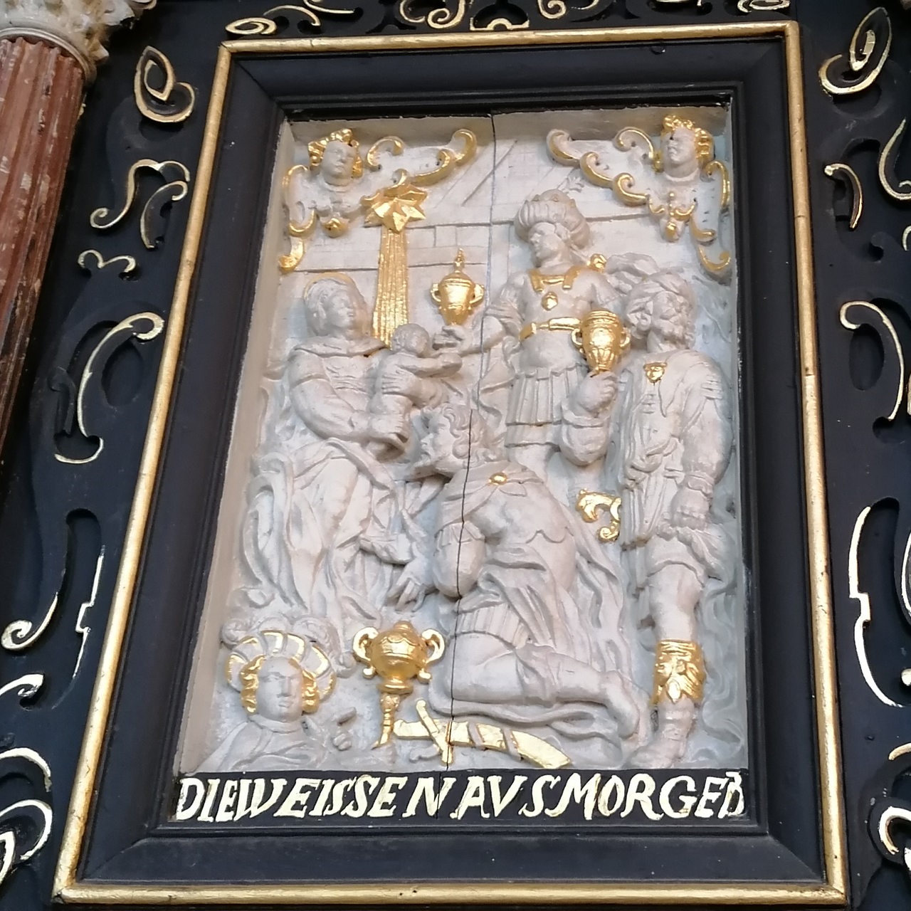 weiß-goldenes Relief in schwarzem Rahmen