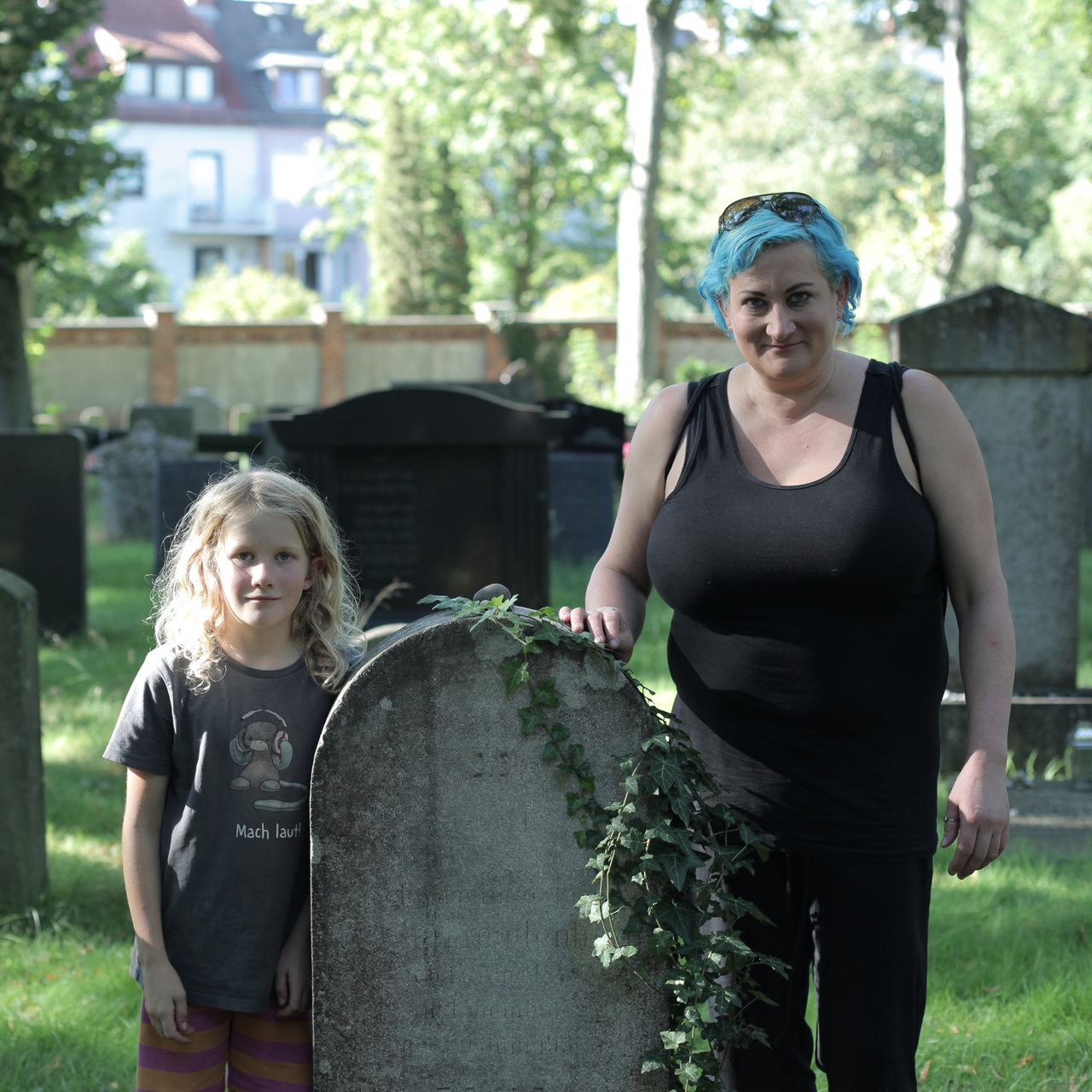 Eine Frau steht mit ihrer Tochter an einem Grab auf dem jüdischen Friedhof in Hastedt
