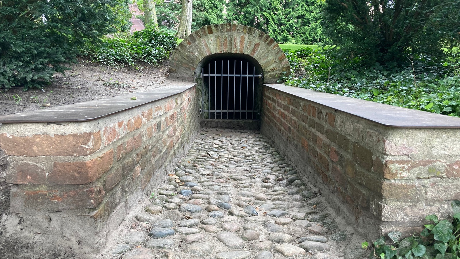 Ein Schlosstunnel, der mit einem Gitter verschlossen ist