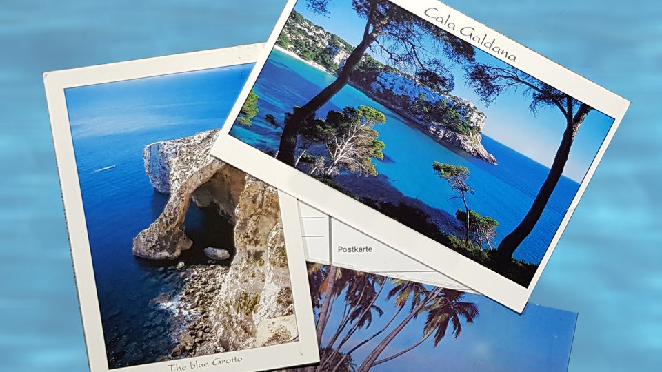 Eine Postkarte zeigt eine Bucht mit einem Strand.