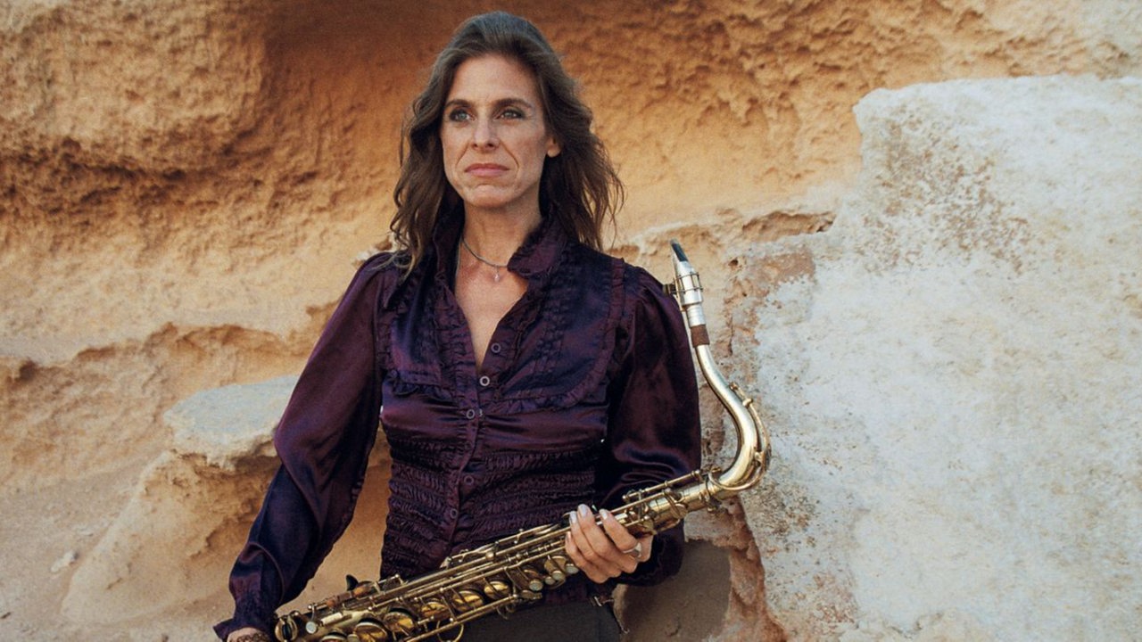 Muriel Grossmann mit Saxophon steht an einer Mauer