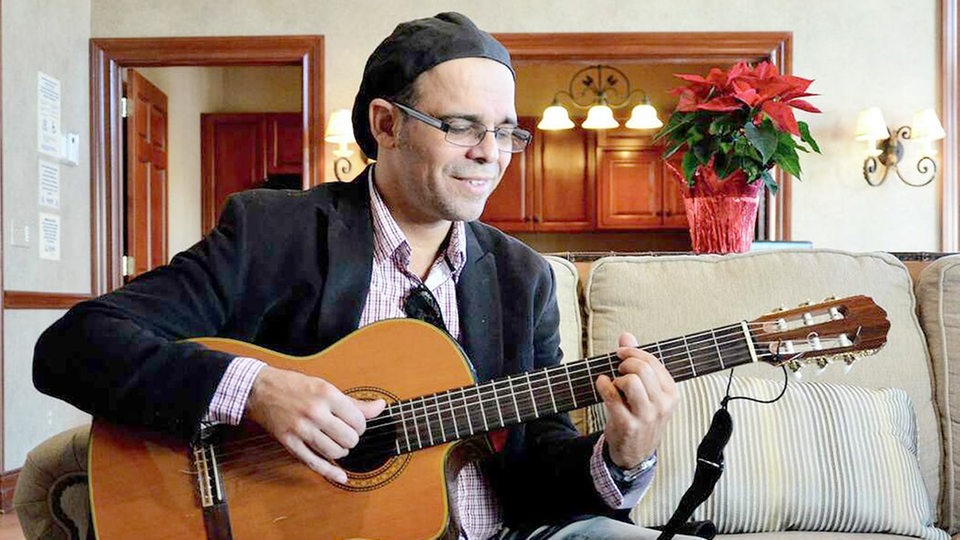 Nanny Assis spielt klassische Gitarre in einem Wohnzimmer