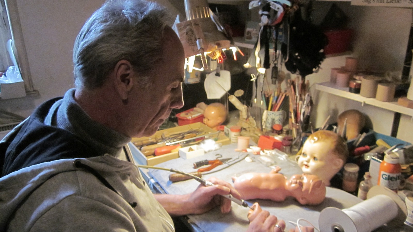 ein Mann repariert eine Puppe