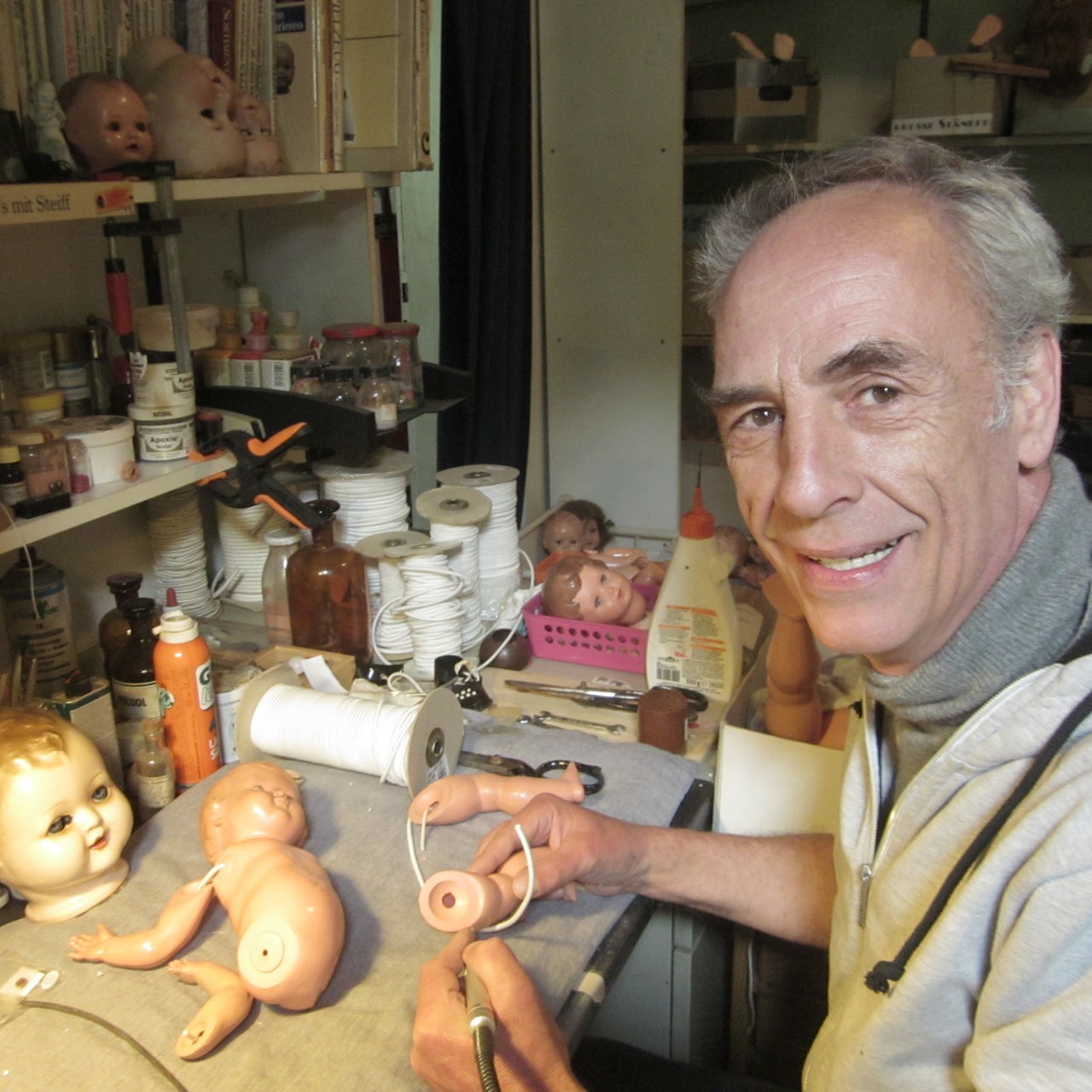 ein Mann repariert eine Puppe