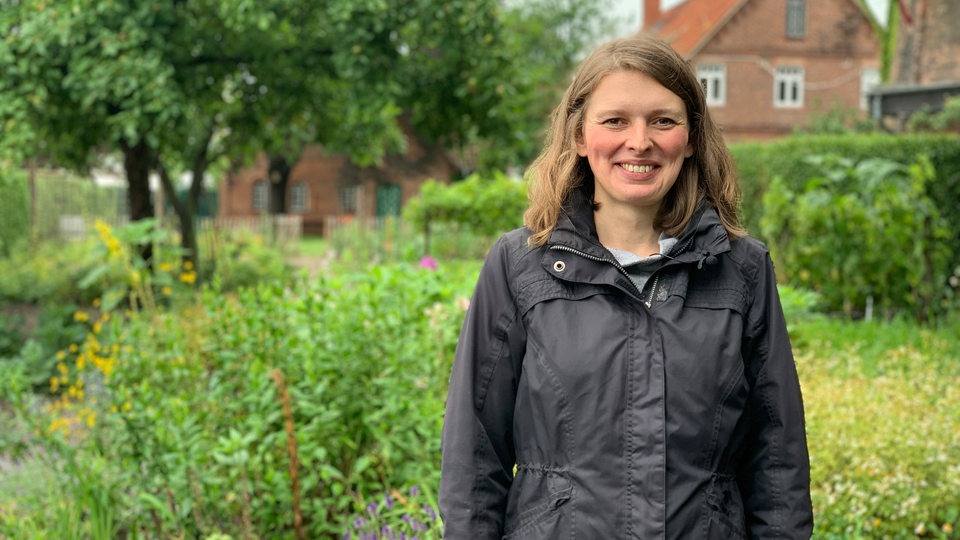 Eine Frau steht in einem großen Garten