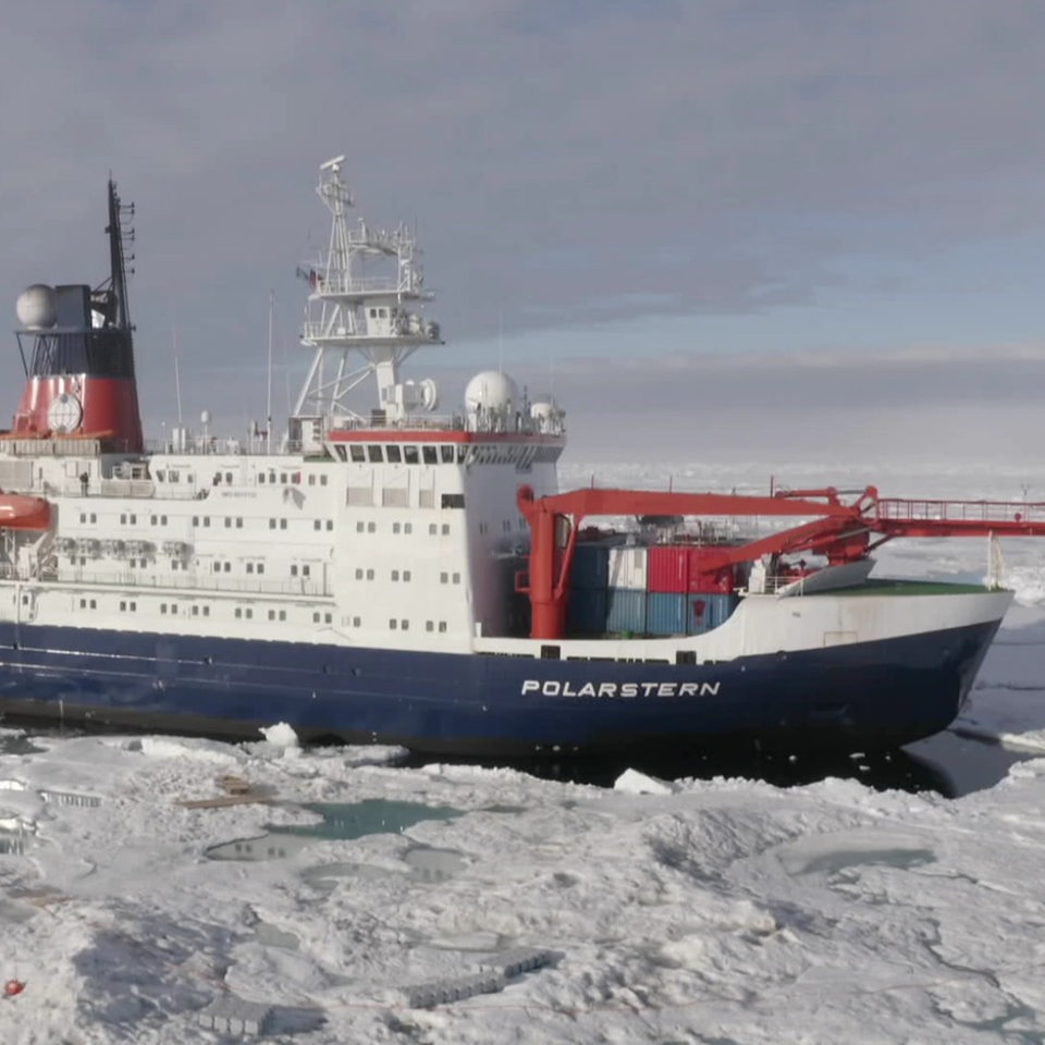 Das Expeditionsschiff "Polarstern" zwischen großen Eisschollen in der Arktis zu sehen.