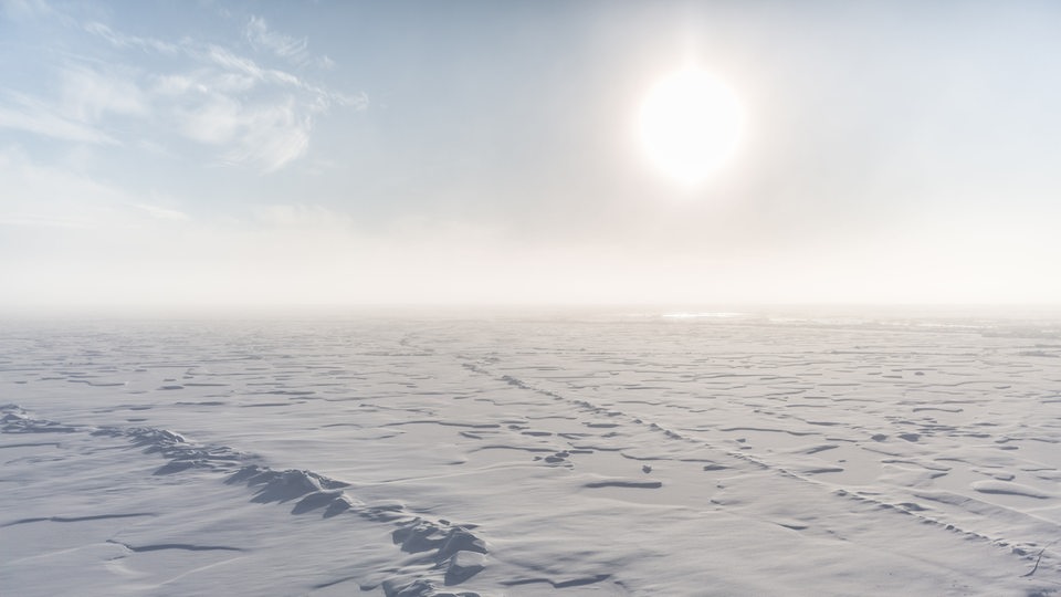 Presseisrücken und zugefrorene, mit Schnee bedeckte Schmelzwassertümpel in der Arktis 