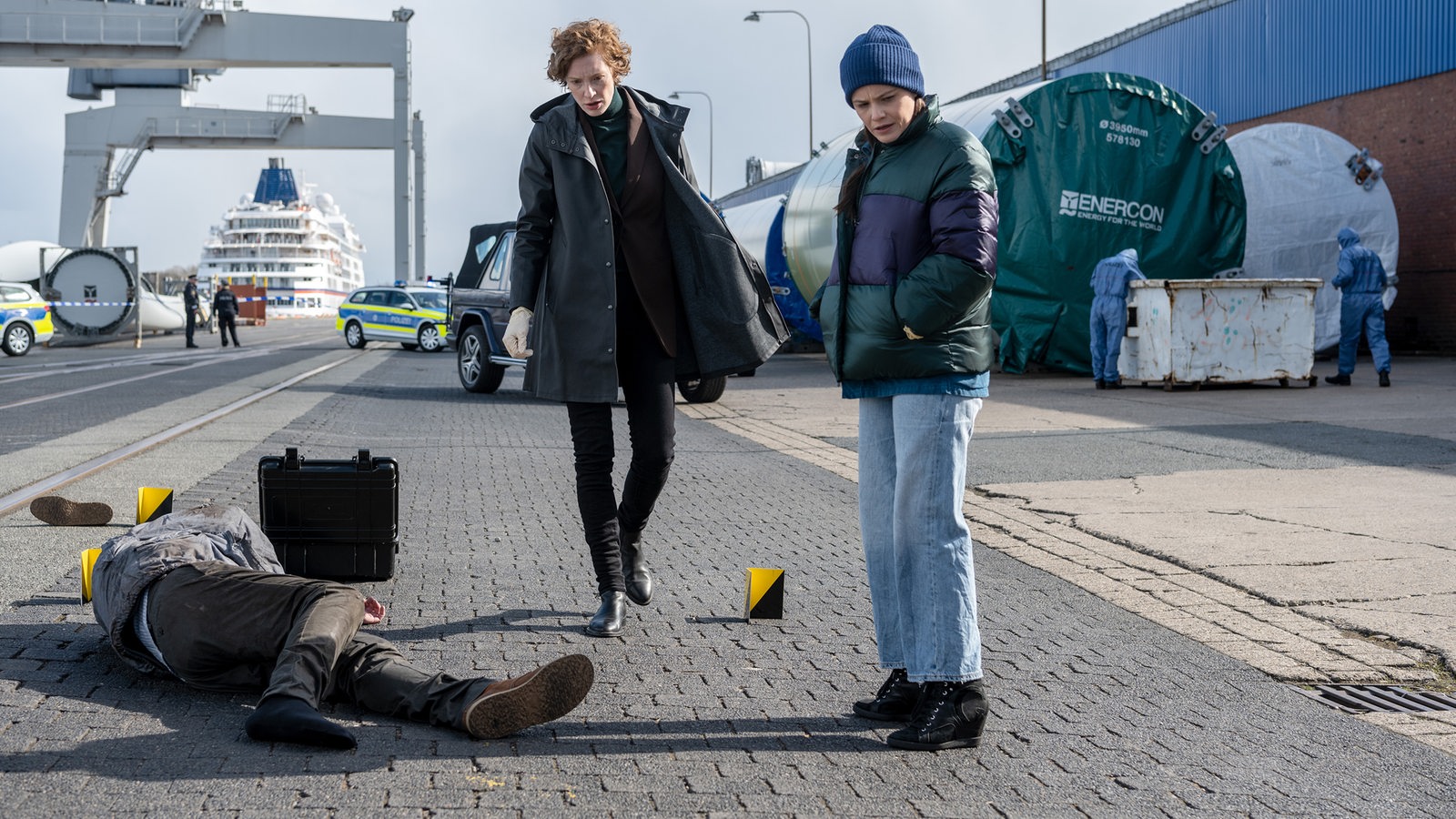 Szene aus dem Tatort "Und immer gewinnt die Nacht" von Radio Bremen, die Kommissarinnen untersuchen eine Leiche am Hafen