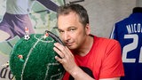 Arnd Zeigler mit einer Weltkugel als Fußball