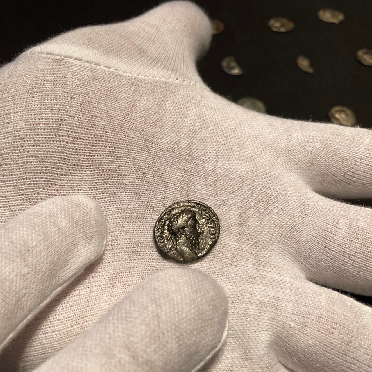 Person hält antike Münze in der Hand.