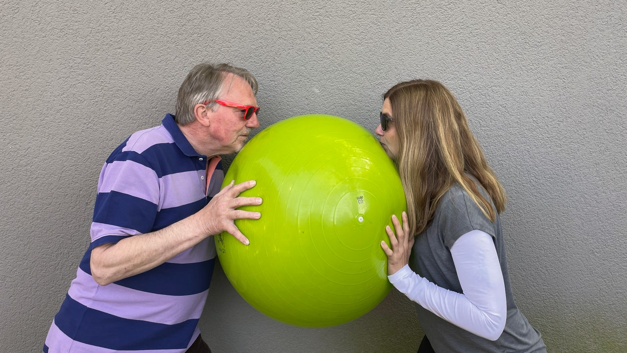 Dietmar Wischmeyer und Tina Voß halten einen Gymnastikball zwischen sich