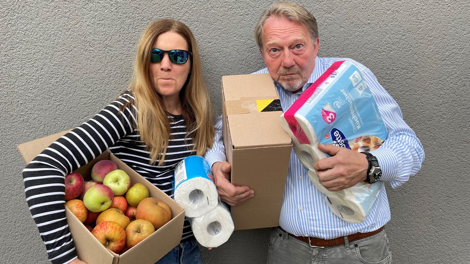 Tina und Dietmar bepackt mit Klopapier und Lebensmitteln