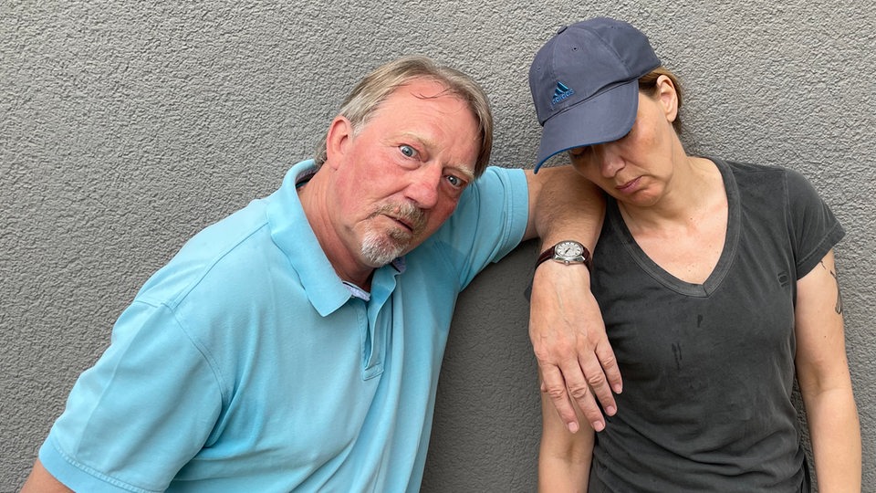Dietmar Wischmeyer und Tina Voß stehen erschöpft vor einer grauen Wand