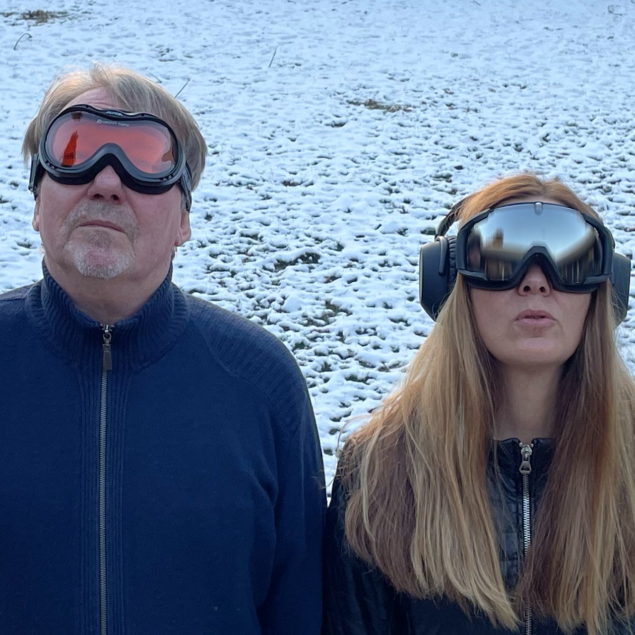 Dietmar Wischmeyer  und Tina Voß stehen im Schnee, sie tragen Ski-Brillen und gucken nach oben