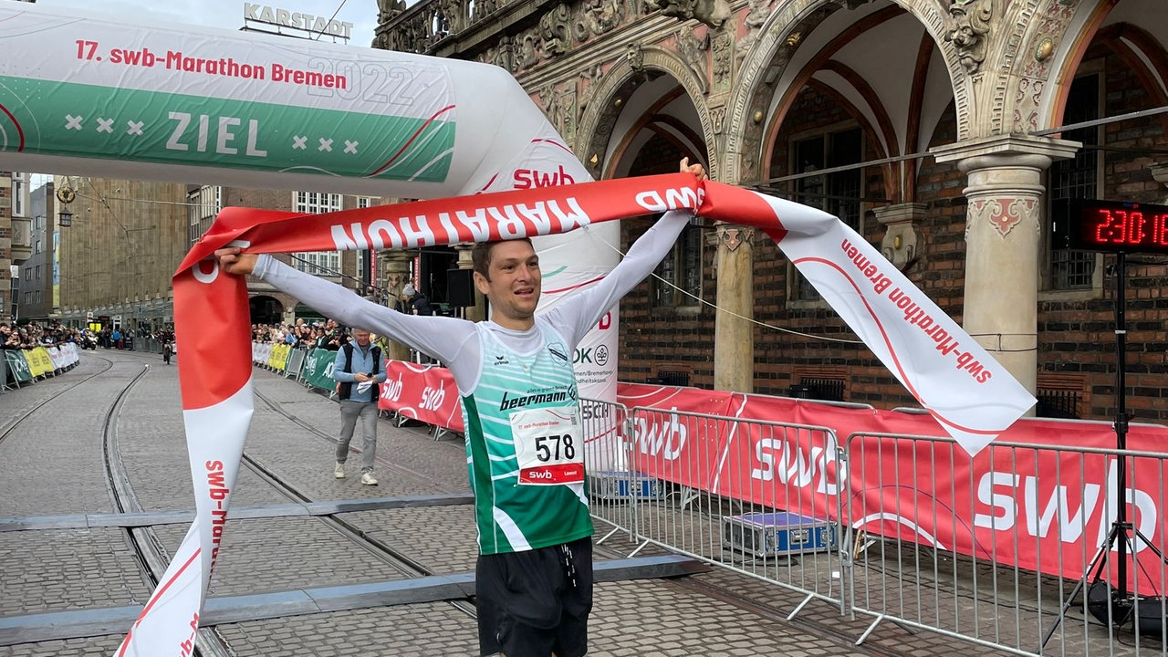 Der Triathlet Lennart Peters feiert seinen Sieg beim Bremen-Marathon.