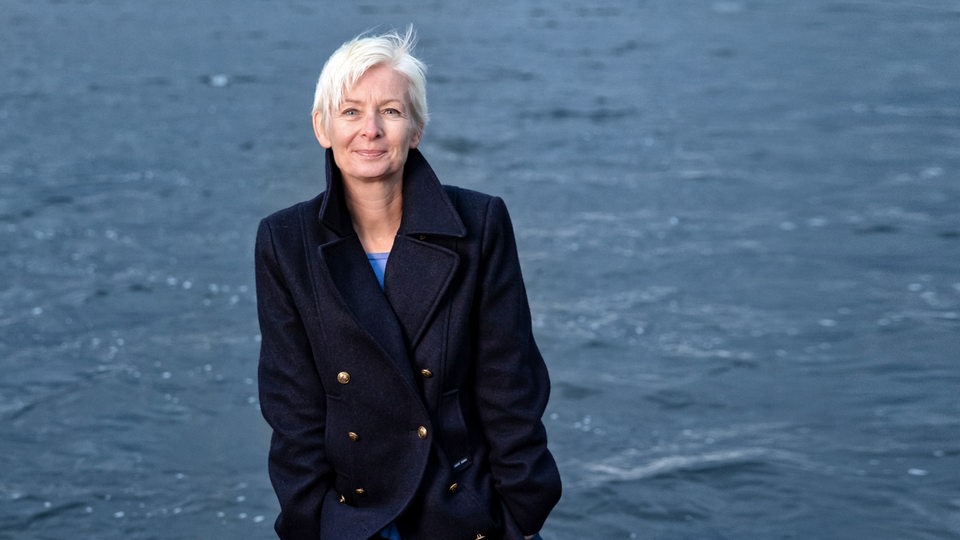 Schriftstellerin Dörte Hansen steht an einem Strand