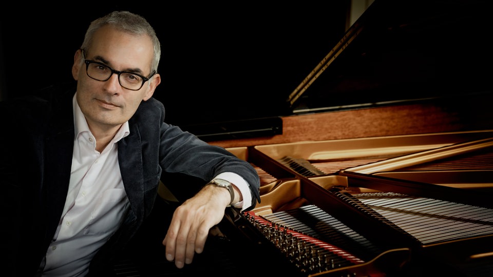 Der Pianist Markus Becker sitzt an einem Flügel.