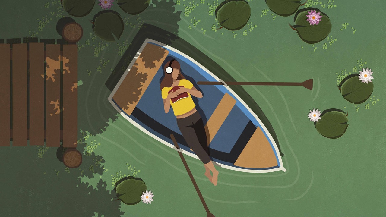 Eine Frau liegt in einem Boot und hat Kopfhörer auf
